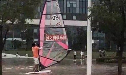[视频]南京江宁暴雨路被淹 俩男子街头玩帆板